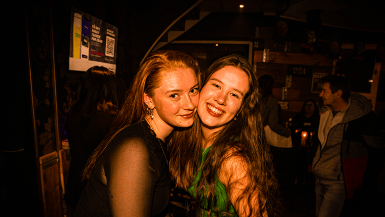 to smilende piger på en bar